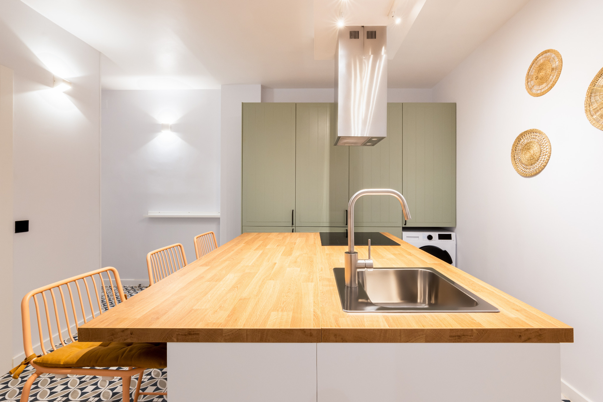 Kitchen Worktop Sanding in Greenwich – finished oak butcher-block island with stainless-steel sink, smooth oiled surface and patterned porcelain tile kitchen floor.