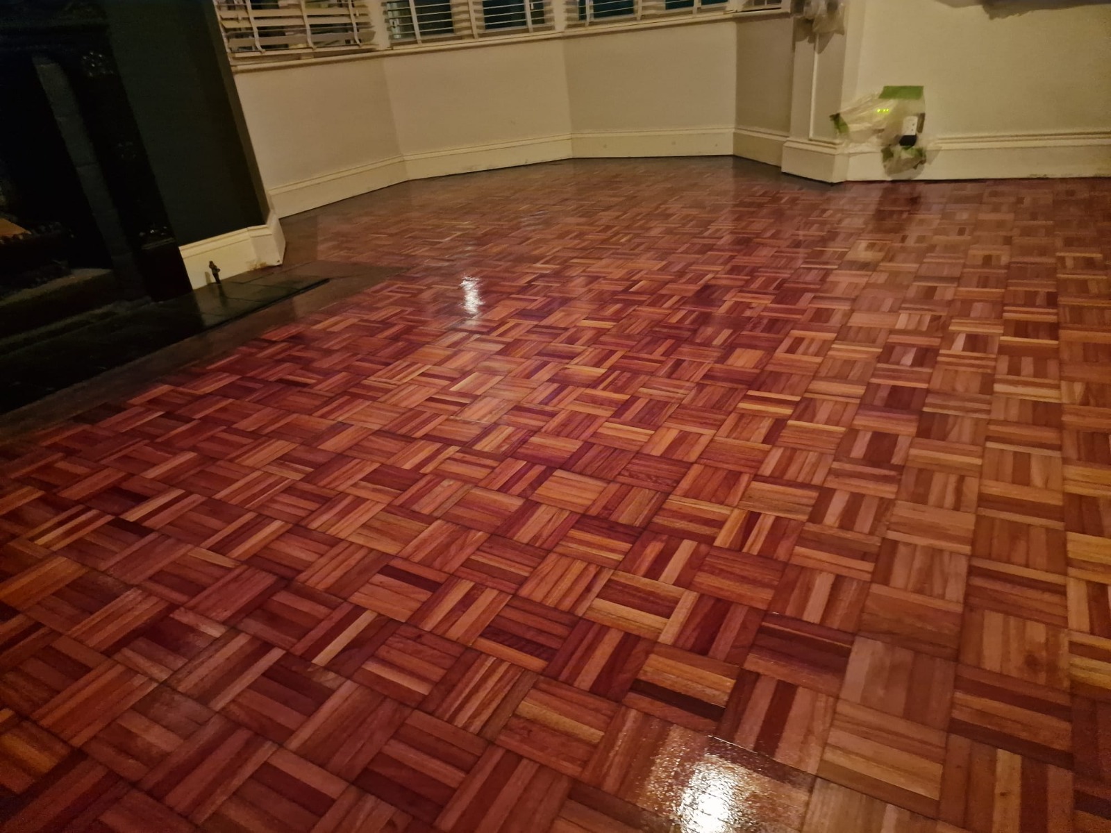 Wood Floor Sanding in Greenwich on a fully restored oak mosaic parquet floor, showing a rich glossy finish across the living room.