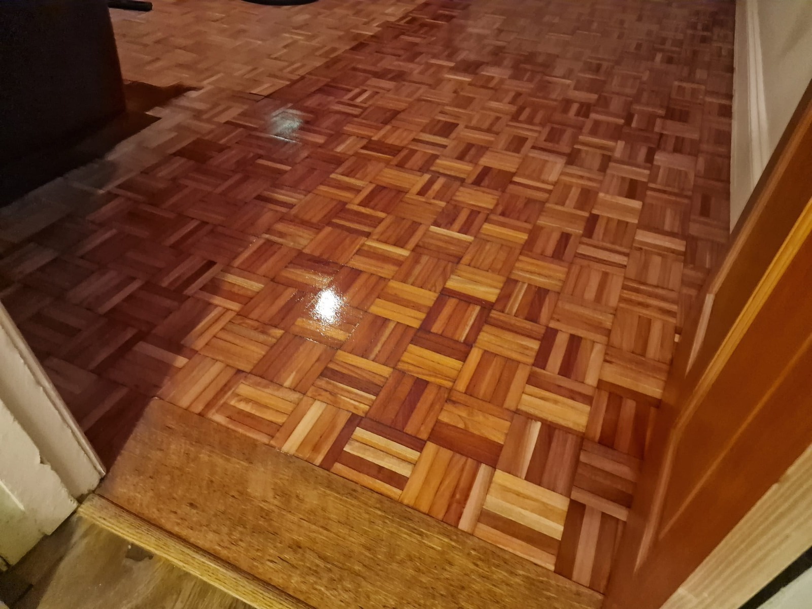 Wood Floor Sanding in Greenwich on a freshly refinished oak mosaic parquet hallway floor with a glossy lacquered finish.